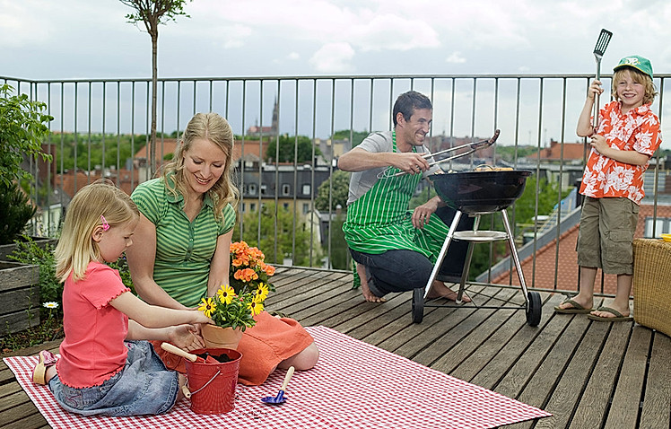 Familie grillt auf der Dachterrasse