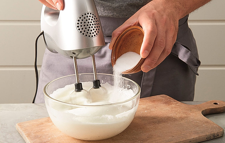 2. In einer zweiten Schüssel 4 Eiweiße mit 30 g Zucker und 1 Prise Salz mit den Quirlen des Handrührgeräts zu einem cremigen Schnee schlagen. Den Eischnee unter die Mehl-Milch-Masse heben.