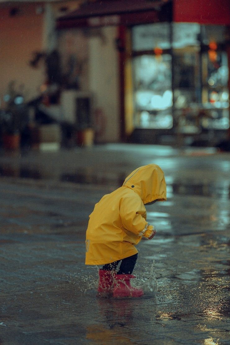 Kind im Regen mit Regenjacke