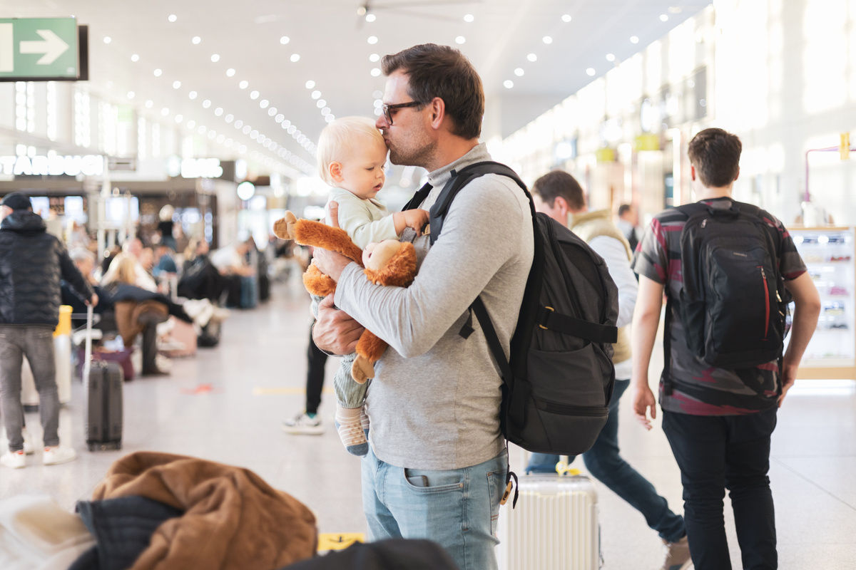 Mann mit Baby am Flughafen