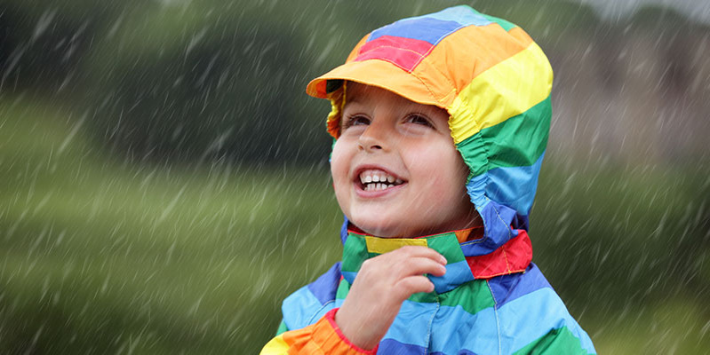 Fröhliches Kind in Regenbekleidung